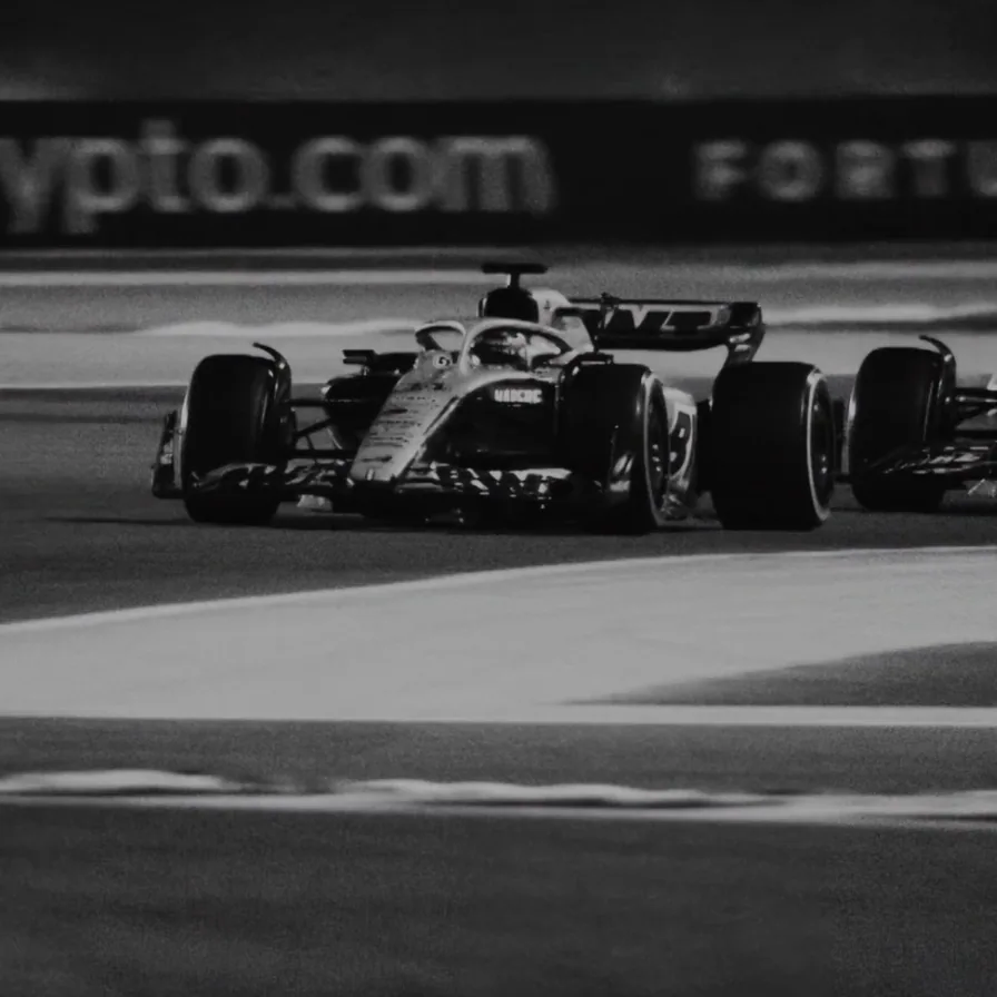 F1 car at speed, black and white